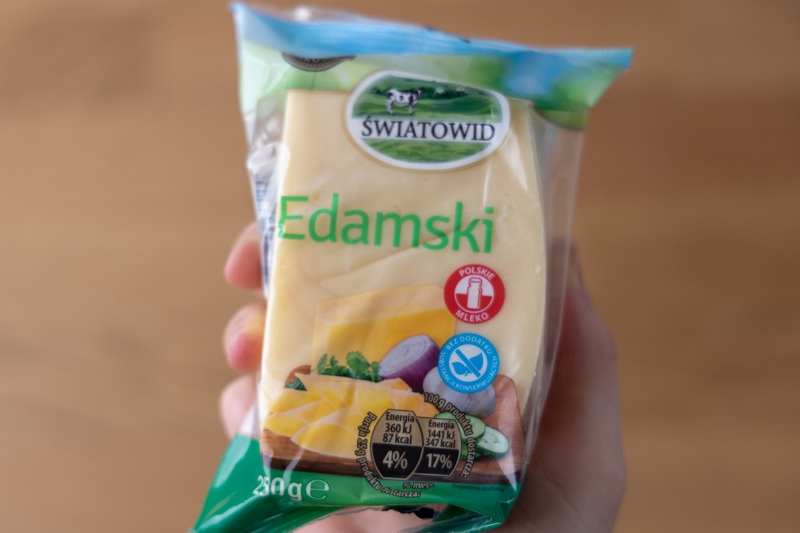 Block of Edam cheese in hand