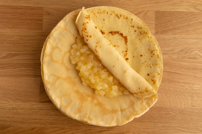 Prepping pancakes filled with applesauce